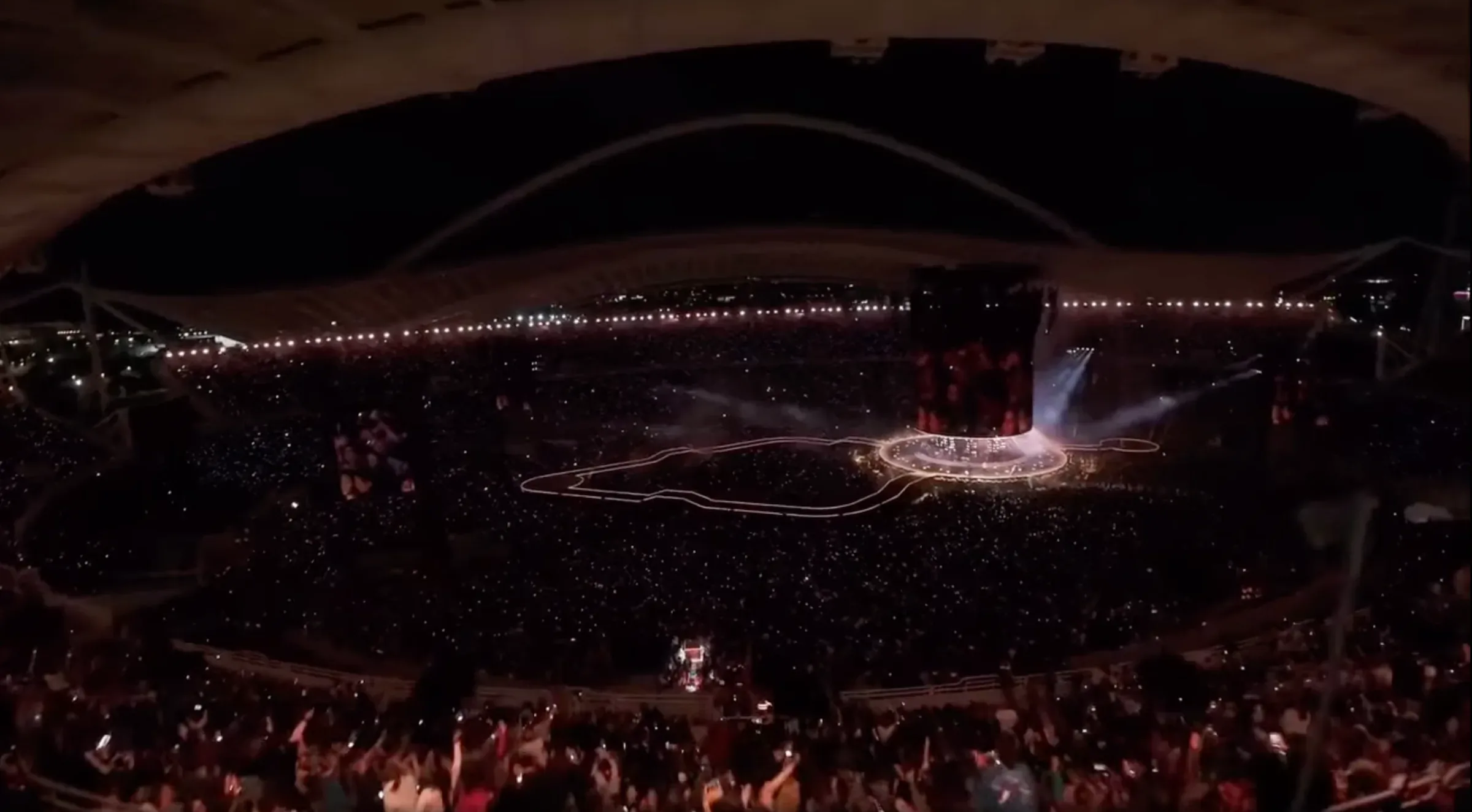 A wide view of the illuminated circular stage and packed stadium at Anna Vissi's OAKA concert in 2026